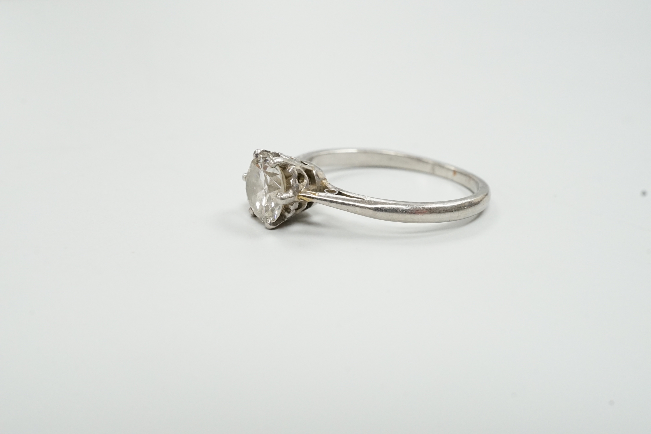 A white metal (stamped plat) and solitaire diamond set ring, size M, gross weight 3.1 grams